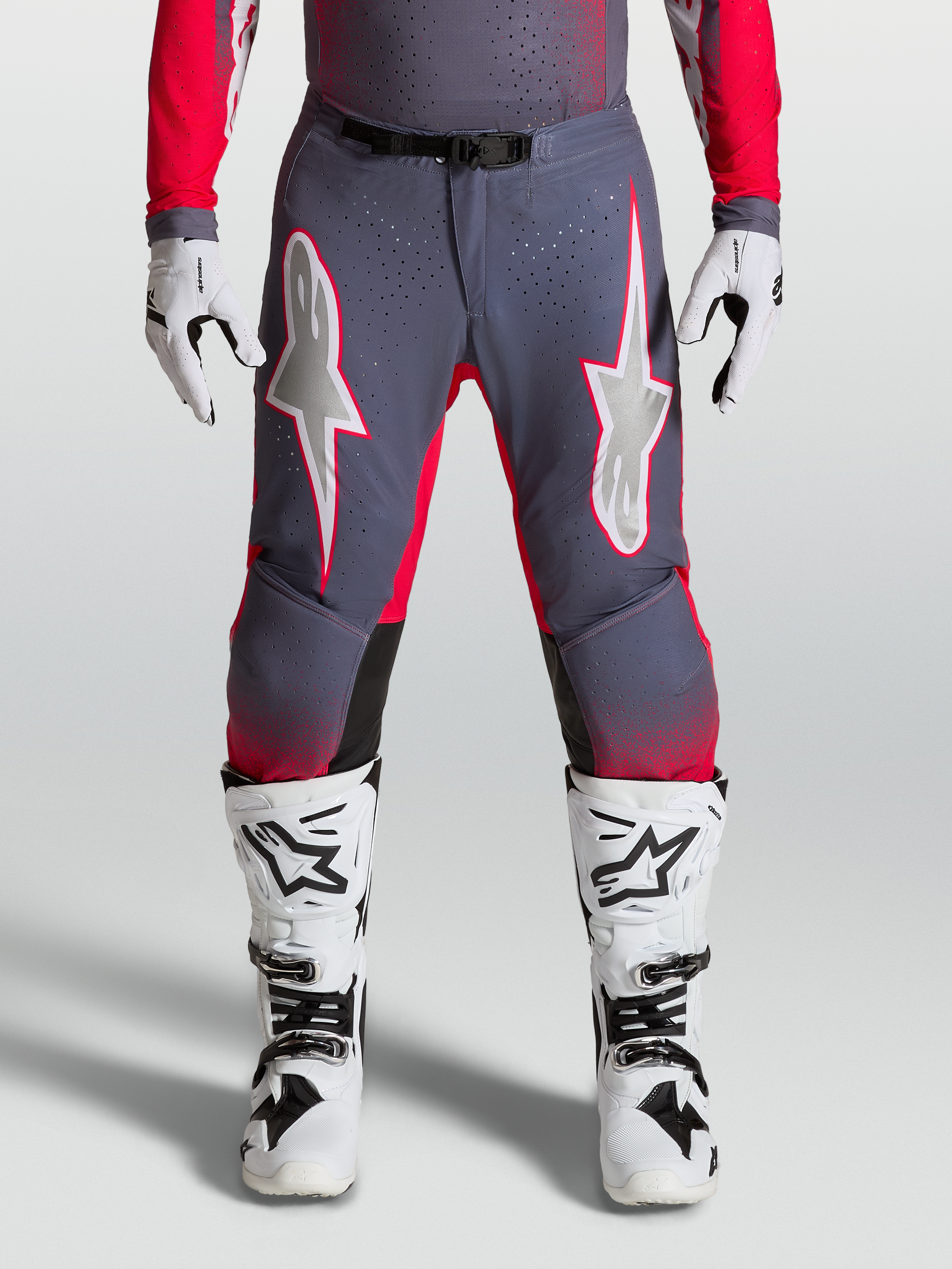 Alpinestars Supertech Hiten AFD broek, motocrossbroek in grijs en rood fluo met geperforeerde stretchpanelen.