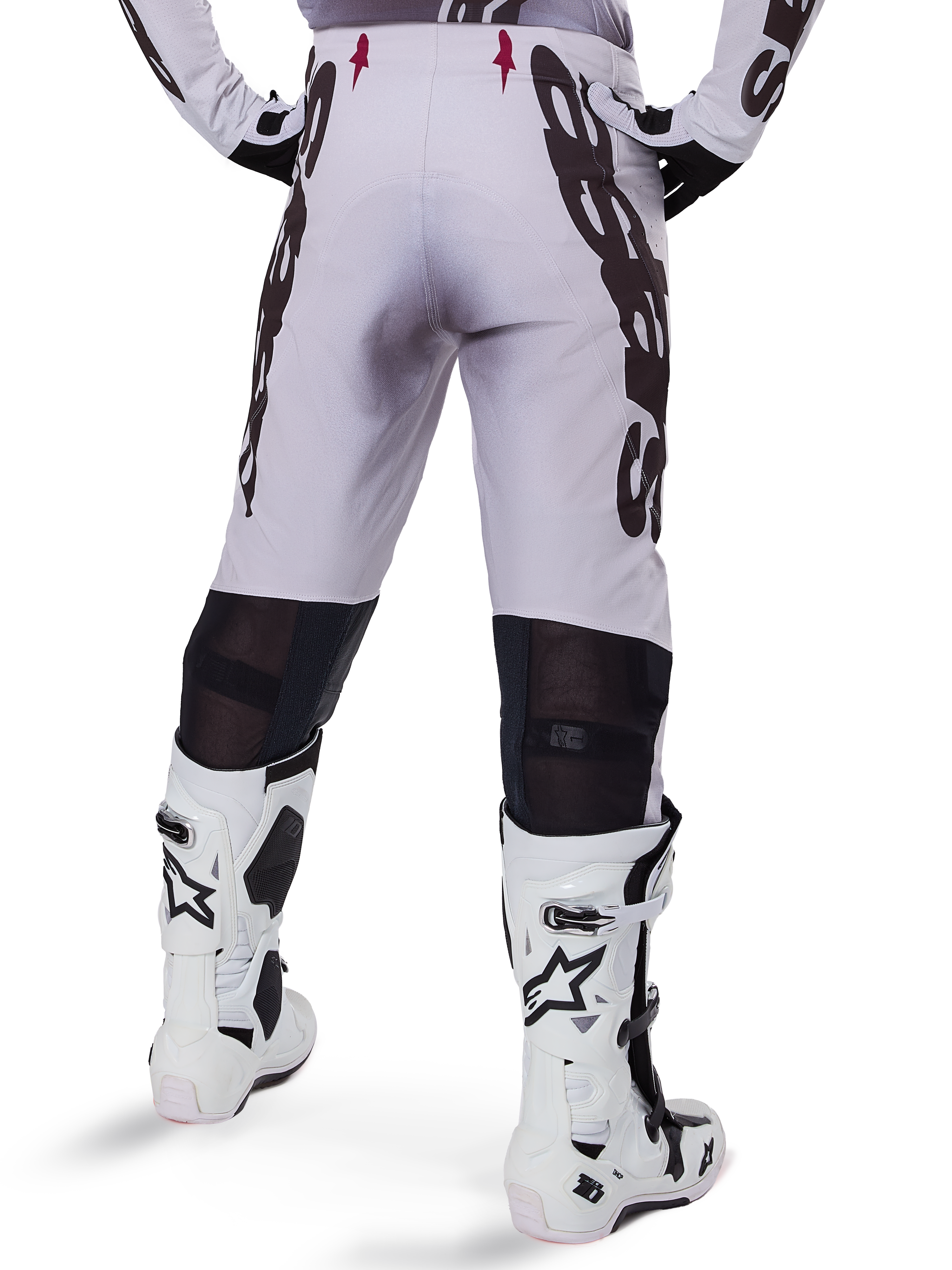 Alpinestars 2025 Supertech Maker Pants, Motocross Pants, Silver and Black, back view showing large black logos on thighs and breathable mesh zones behind the knees, worn with white Alpinestars boots.