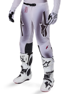 Alpinestars 2025 Supertech Maker Pants, Motocross Racing Pants, Silver and Black, featuring large star logos and red lettering, shown with matching white boots and gloves