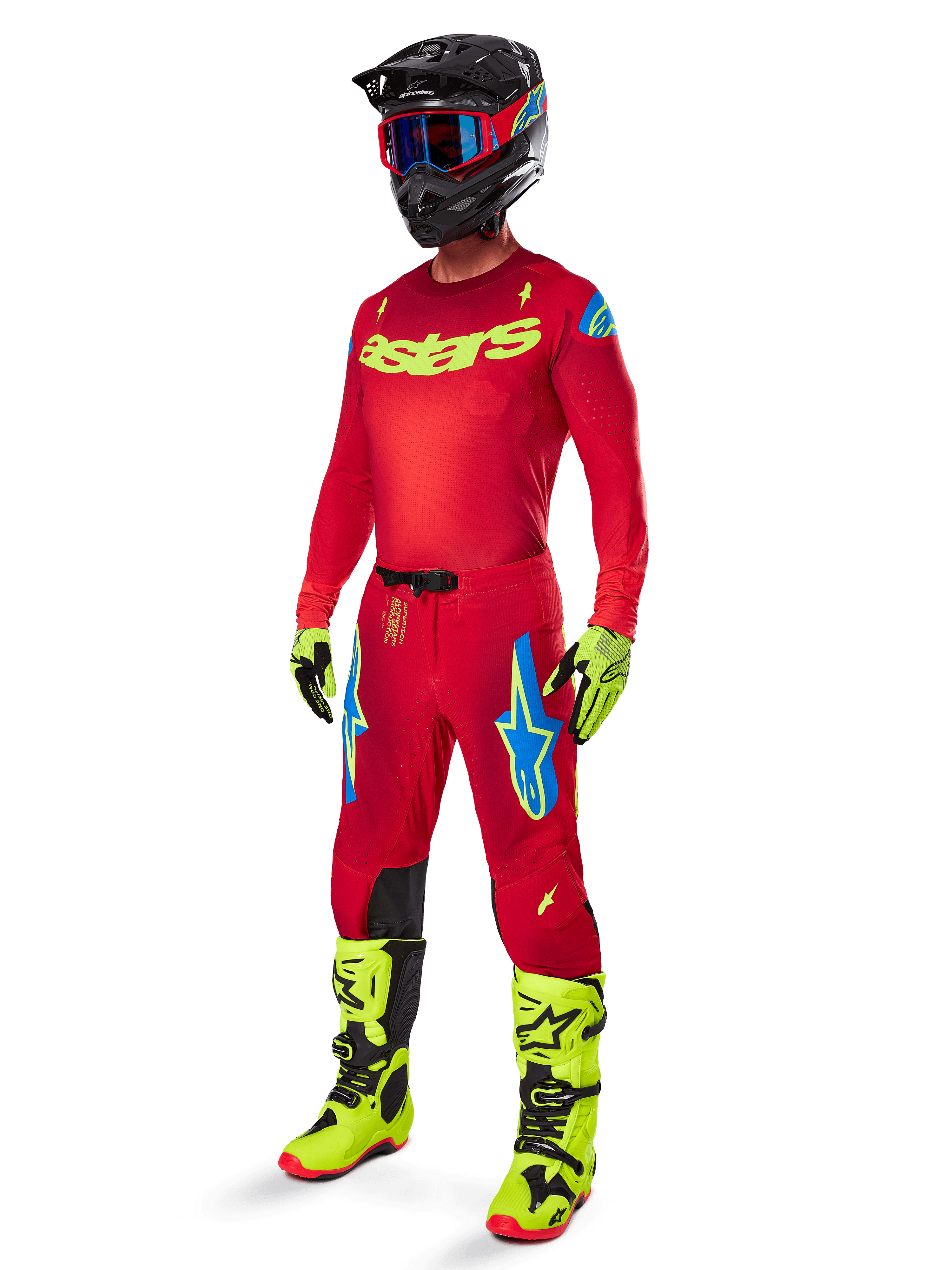 Motocross-Fahrer in kompletter Alpinestars Rennbekleidung, 2025 Supertech Maker Hose in Bright Red und Yellow Fluo, passendes rotes Trikot mit neongelbem Logo, neongelbe und schwarze Stiefel, schwarzer Helm mit blauer Brille, professionelles Outfit für den Offroad-Rennsport