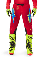 Alpinestars 2025 Supertech Maker Hose, Motocross-Hose, Hellrot und Neongelb, mit blauen Astars-Logos auf den Oberschenkeln, belüfteten Perforationen und schwarzen Knieinnenseiten-Einsätzen, getragen mit passenden neongelben Stiefeln und Handschuhen