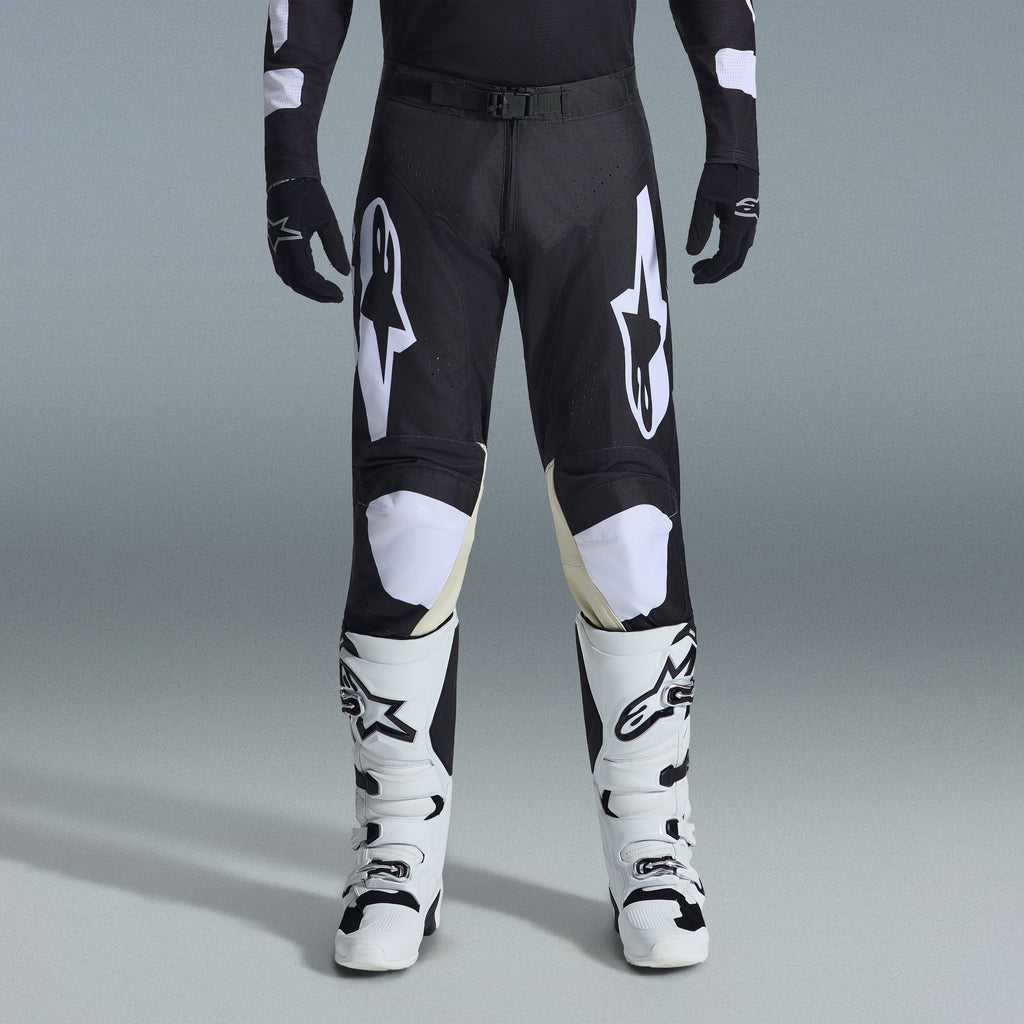 Alpinestars 2026 Racer Air Riway Gear Set, Black and White motocross pants with tan inner knee panels, paired with white racing boots and black gloves, lightweight ventilated off-road racing gear