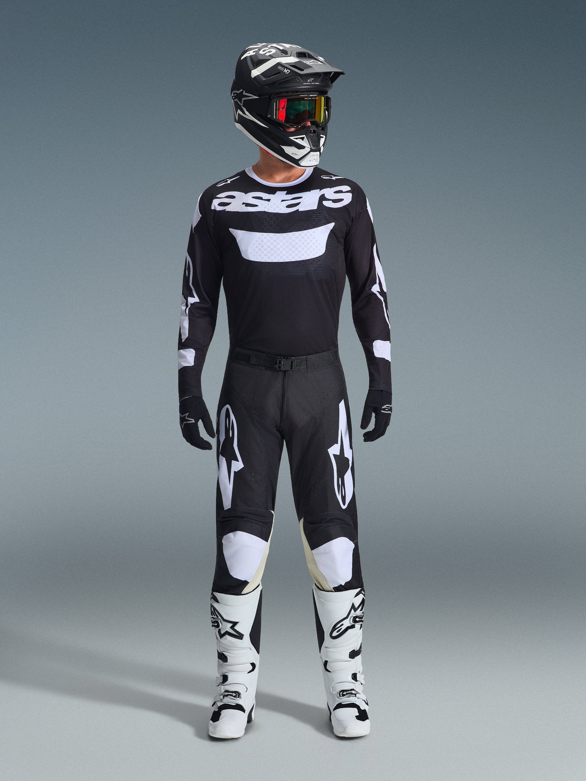 Alpinestars 2026 Racer Air Riway Ausrüstungsset, komplette Motocross-Ausrüstung, Schwarz und Weiß, schwarzes Jersey mit weißem 'astars' Branding, passende Hose mit weißen Kniepaneelen, weiße Stiefel mit schwarzen Schnallen, schwarzer Helm mit rot getönter Brille, professionelle Offroad-Rennausrüstung