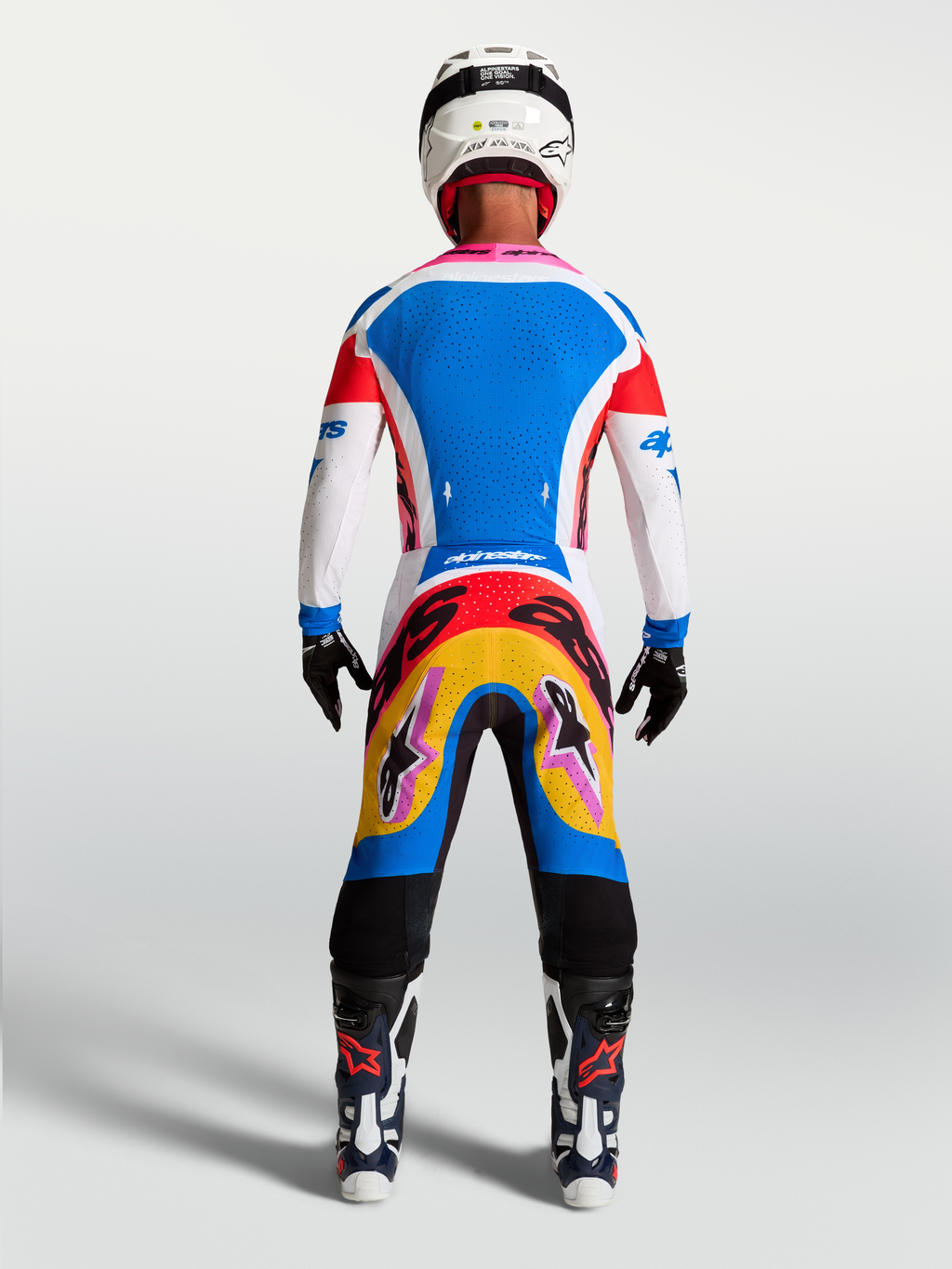 Ensemble Alpinestars Supertech Dyna, maillot et pantalon de motocross homme, bleu et blanc, graphismes vibrants, vue de dos.