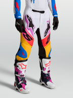 Alpinestars Supertech Dyna, pantalons de motocross pour homme, blancs et bleus, tissu rip-stop extensible et panneaux en cuir de chèvre, portés par un mannequin, équipement de course tout-terrain premium