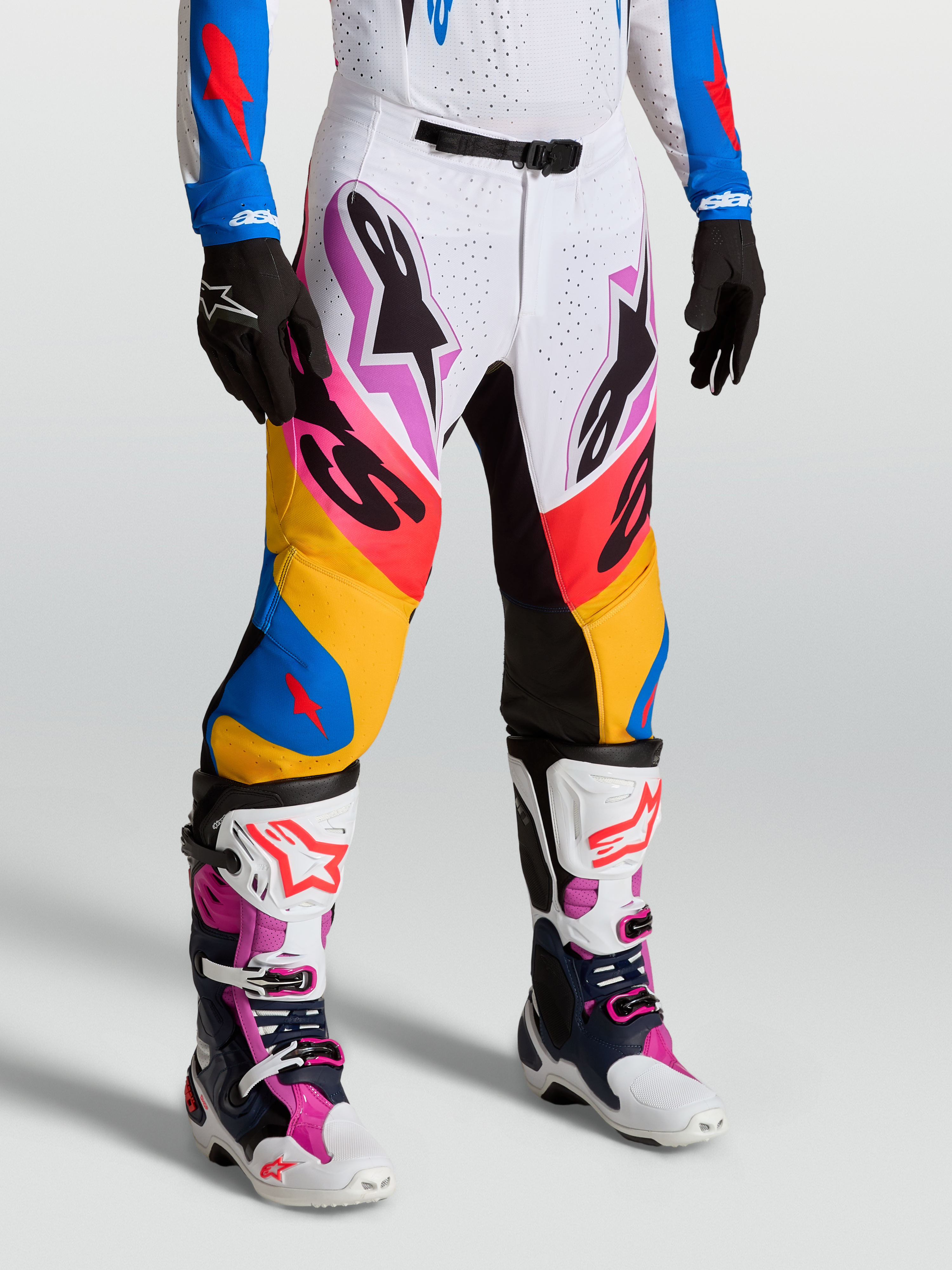Alpinestars Supertech Dyna, pantalons de motocross pour homme, blancs et bleus, tissu rip-stop extensible et panneaux en cuir de chèvre, portés par un mannequin, équipement de course tout-terrain premium