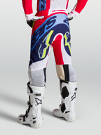 Alpinestars Supertech Dyna Broek, rood, wit en navy blauw, motocross broeken met atletische racepasvorm op model.