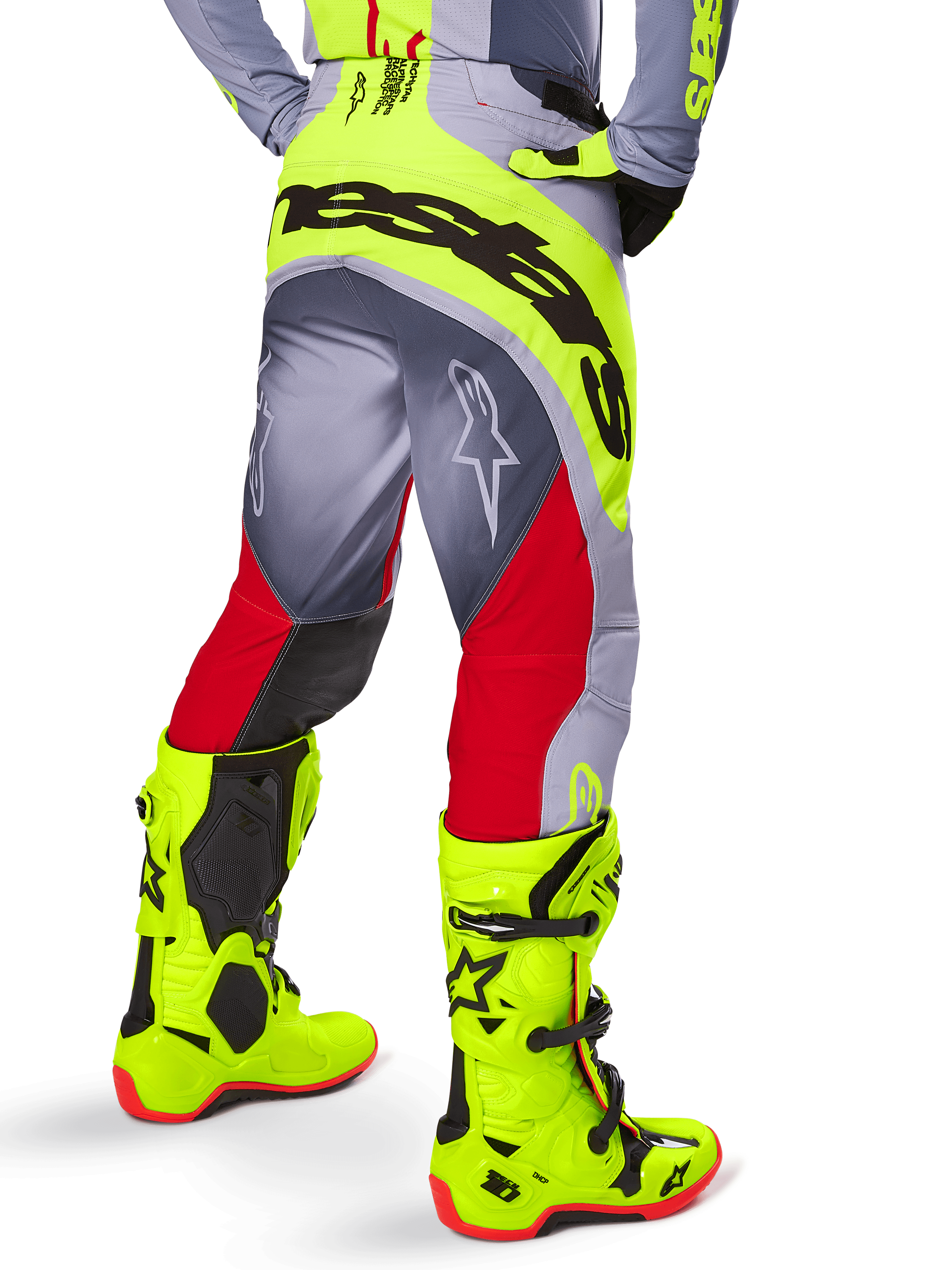 Alpinestars Techstar Melt Pants 2025, pantalon de motocross, rouge vif et gris avec jaune fluorescent, vue arrière montrant le logo Alpinestars noir sur l'assise, associé à des bottes jaune vif assorties, conçu pour la performance tout-terrain