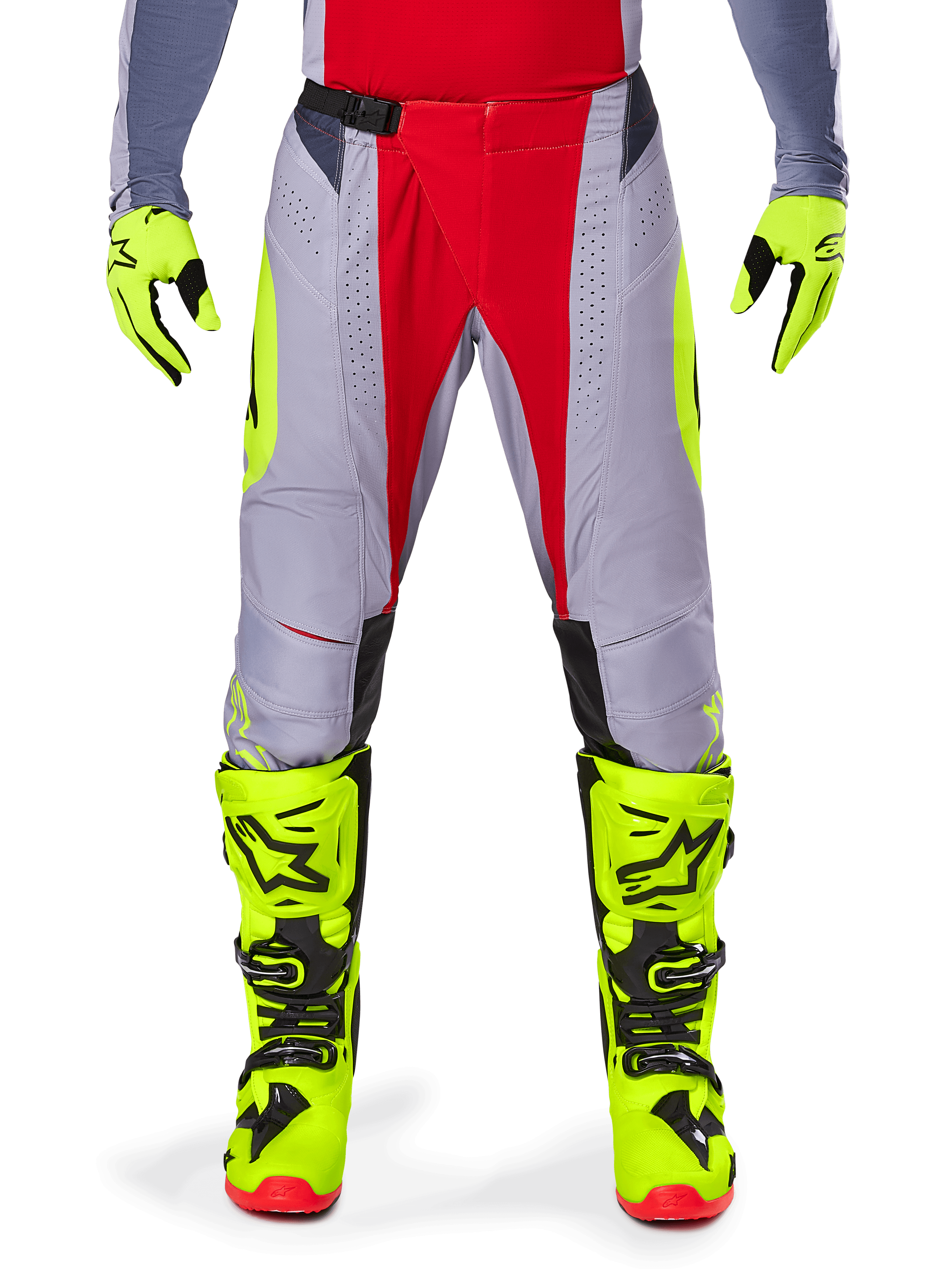 Alpinestars Techstar Melt Pants 2025, pantalon de motocross, rouge et gris avec accents jaune fluo, perforations découpées au laser pour la ventilation, porté avec des gants et des bottes jaune fluo, équipement haute performance pour la course tout-terrain
