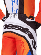 Alpinestars 2025 Techstar Melt crossbroek, motorcross broek, oranje en blauw, close-up achteraanzicht van het zitvlak en de tailleband, opvallende zwarte branding op witte achtergrond, oranje panelen met rode sterlogo's, atletische performance-uitrusting voor off-road racen