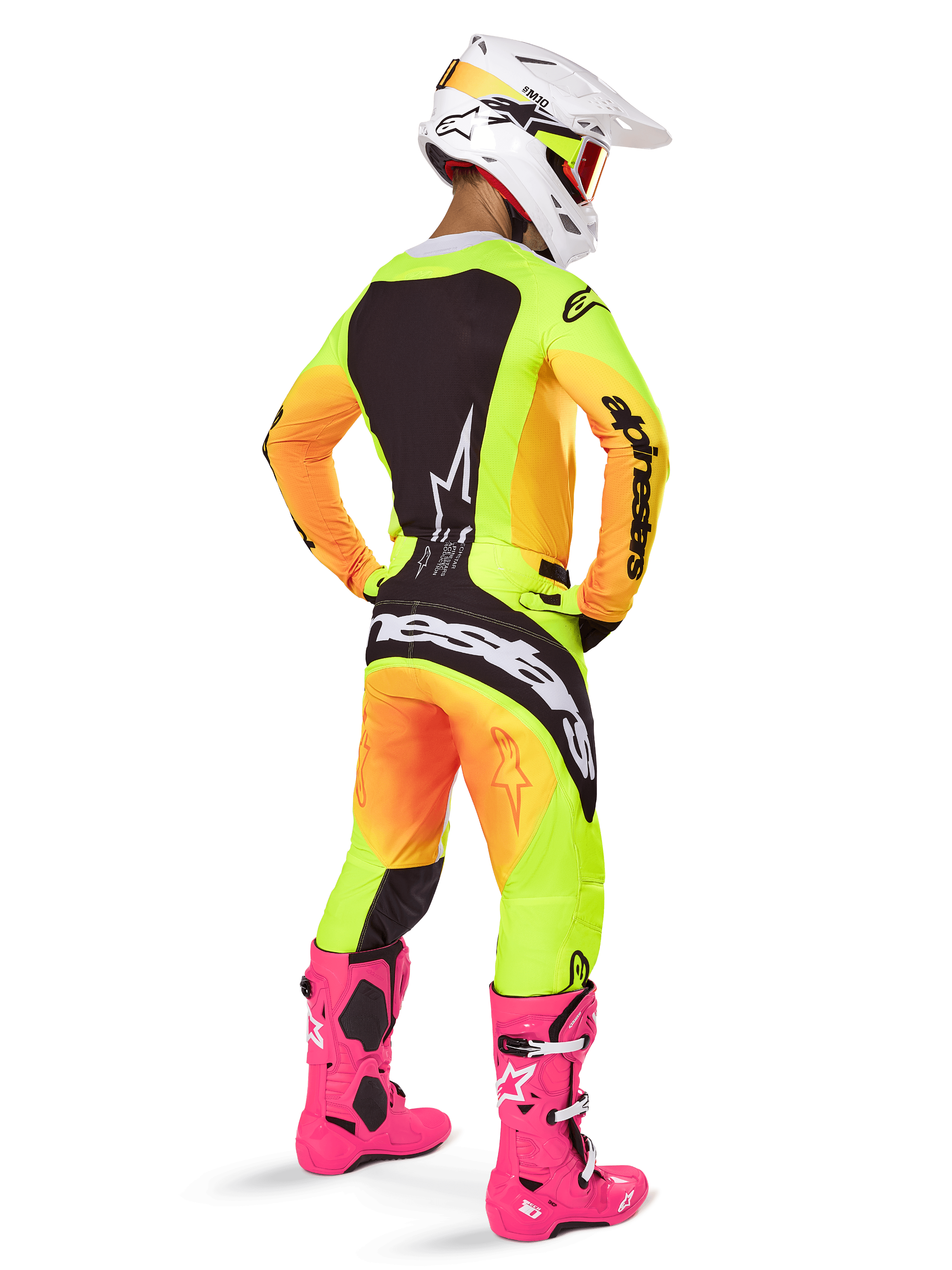 Alpinestars 2025 Techstar Melt Gear Set, motorcrosser van achteren gezien, geel en oranje gradiënt jersey en broek met zwarte panelen, witte helm met rode crossbril, felroze laarzen, gecoördineerde race-outfit voor off-road prestaties
