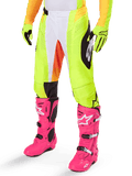 Alpinestars 2025 Techstar Melt Hose, Motocross-Hose, Neongelb mit weißen und orangen Akzenten, schwarze Muster an den Seiten, getragen mit leuchtend rosa Motocross-Stiefeln und neongelben Handschuhen, perforierte Belüftung, strapazierfähige Offroad-Rennausrüstung