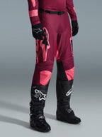 Alpinestars 2026 Racer Riway Pants, Motocross Pants, Dark Red Coral, featuring large pink star logos and black inner knee panels, worn with black motocross boots and black gloves, athletic race fit for off-road riding