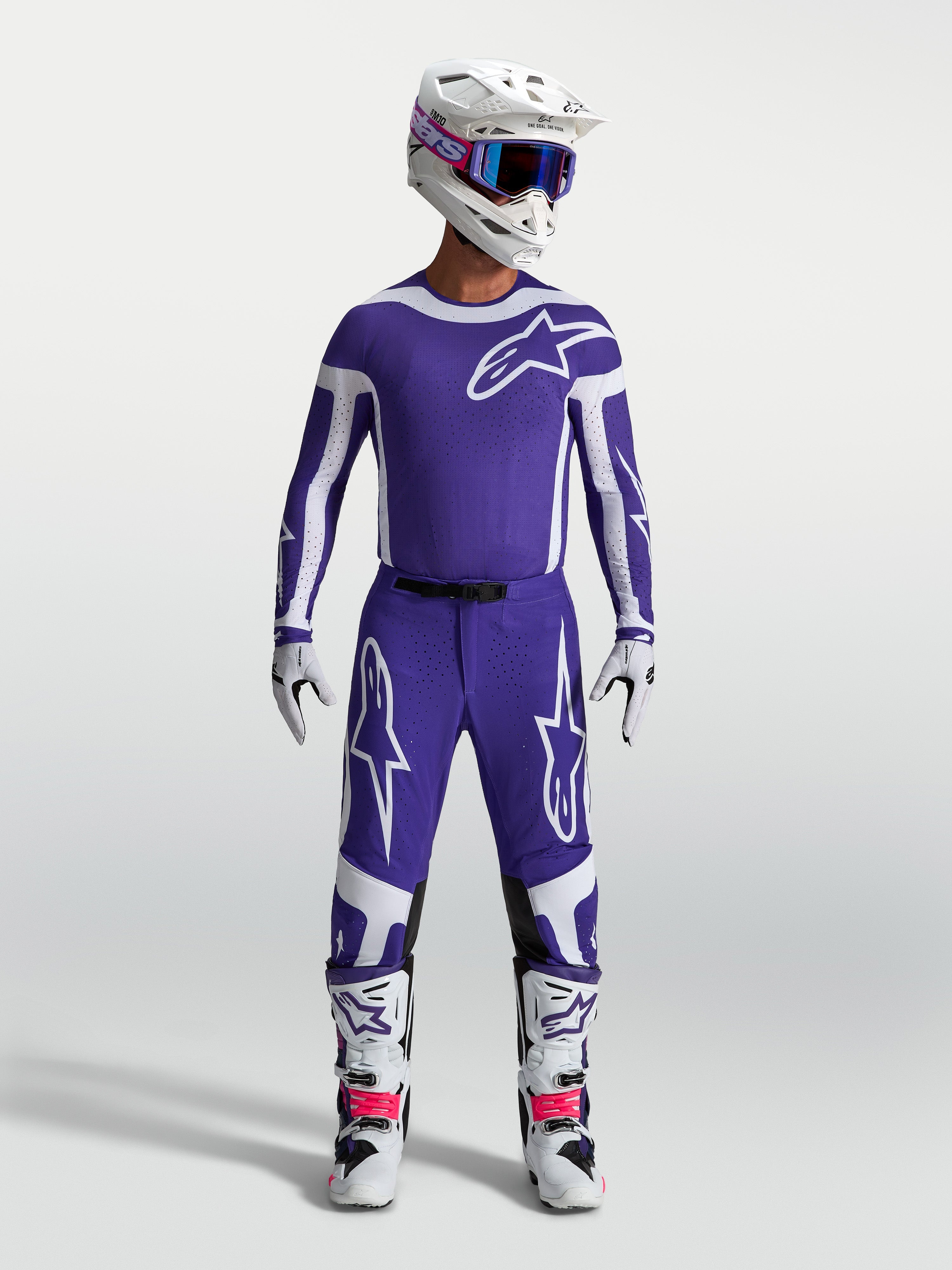 Alpinestars Supertech Vesta Broek, heren-motocrossbroek in donkerblauw en wit, atletische pasvorm en rip-stop stof, gedragen door een model met complete off-road race-uitrusting.