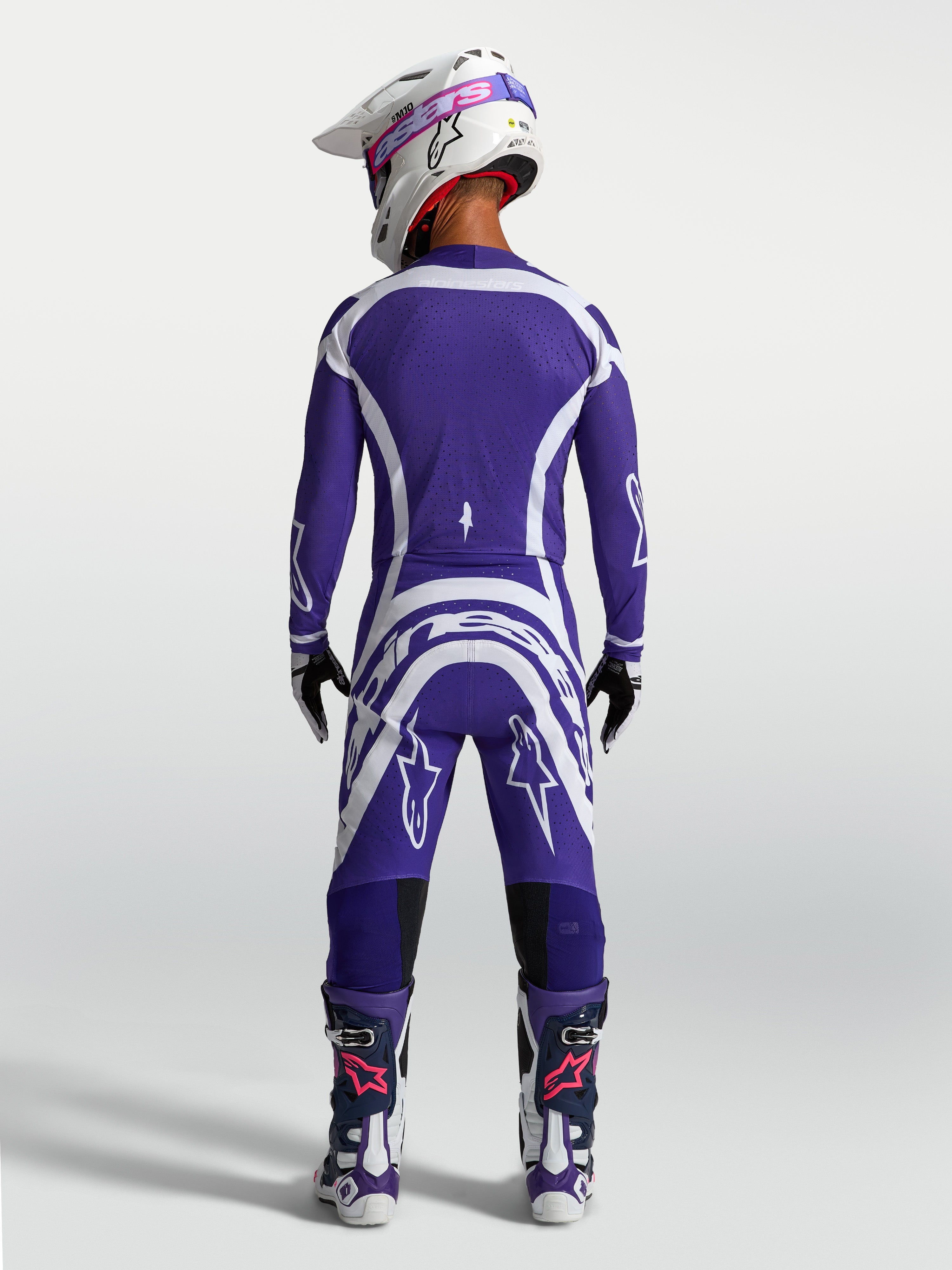 Alpinestars Supertech Vesta broek en jersey, donkerblauwe en witte motocross-uitrusting van achteren gezien op een model.