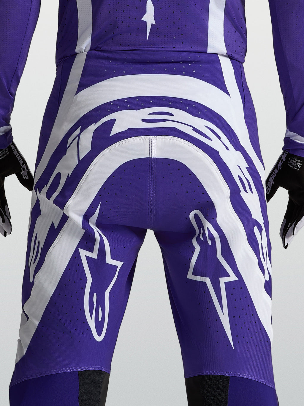 Alpinestars Supertech Vesta broek, heren motocrossbroek in blauw en wit, achteraanzicht met logo en ventilatieperforaties.