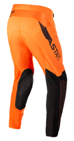 Alpinestars Supertech Blaze broek, motorcrossbroek, oranje en zwart met fluoriserend geel, driekwart achteraanzicht toont zwarte leren knieversterkingen, ASTARS-branding op de dij en ademende mesh-panelen, ontworpen voor professioneel terreinrijden.