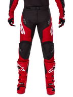 Alpinestars 2025 Racer Veil Gear Set, motorcrossbroek en laarzen, rood en zwart, opvallende witte logo's op de bovenbenen en laarzen, gedragen met bijpassende handschoenen, duurzame textielconstructie met lederen verstevigingen voor off-road racing