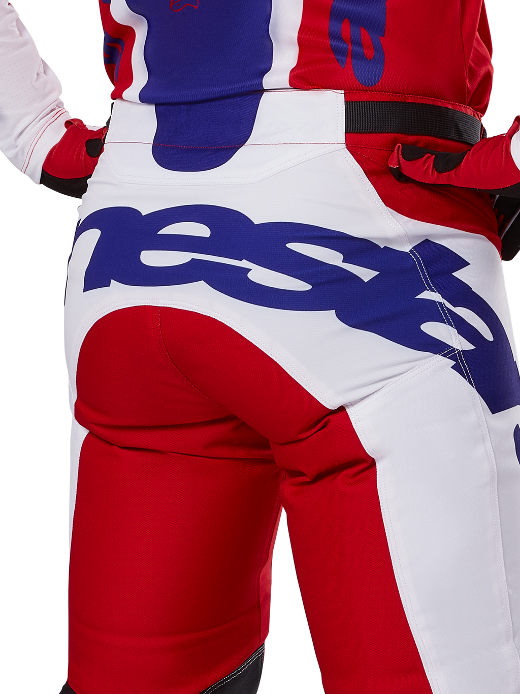 Alpinestars 2025 Racer Veil Hose, Motocross-Hose, Leuchtendes Rot und Weiß mit blauem Branding, Detailansicht der Rückseite des Gesäßbereichs mit einem großen Alpinestars-Logo, getragen als Teil eines abgestimmten Offroad-Rennoutfits