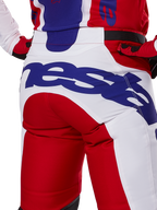 Alpinestars 2025 Racer Veil Hose, Motocross-Hose, Leuchtendes Rot und Weiß mit blauem Branding, Detailansicht der Rückseite des Gesäßbereichs mit einem großen Alpinestars-Logo, getragen als Teil eines abgestimmten Offroad-Rennoutfits