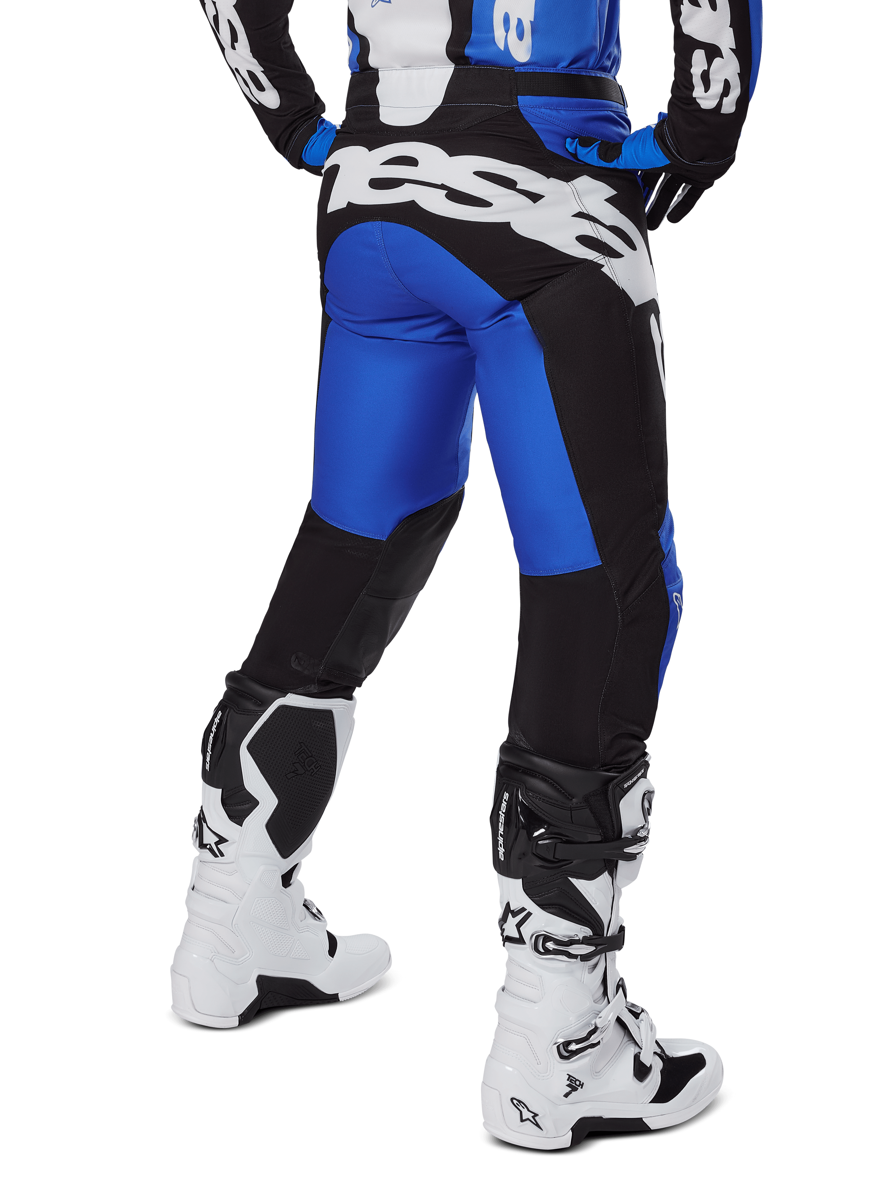 Alpinestars 2025 Racer Veil broek, motorcrossbroek, blauw en zwart, achteraanzicht met grote witte branding op het zitvlak, gedragen met bijpassende jersey en witte laarzen, duurzaam technisch materiaal voor off-road rijden