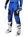 Alpinestars 2025 Racer Veil broek, motorcrossbroek, blauw en zwart met witte grafische accenten, gedragen met bijpassende blauwe jersey, handschoenen en witte laarzen, duurzame beschermende uitrusting voor off-road racen