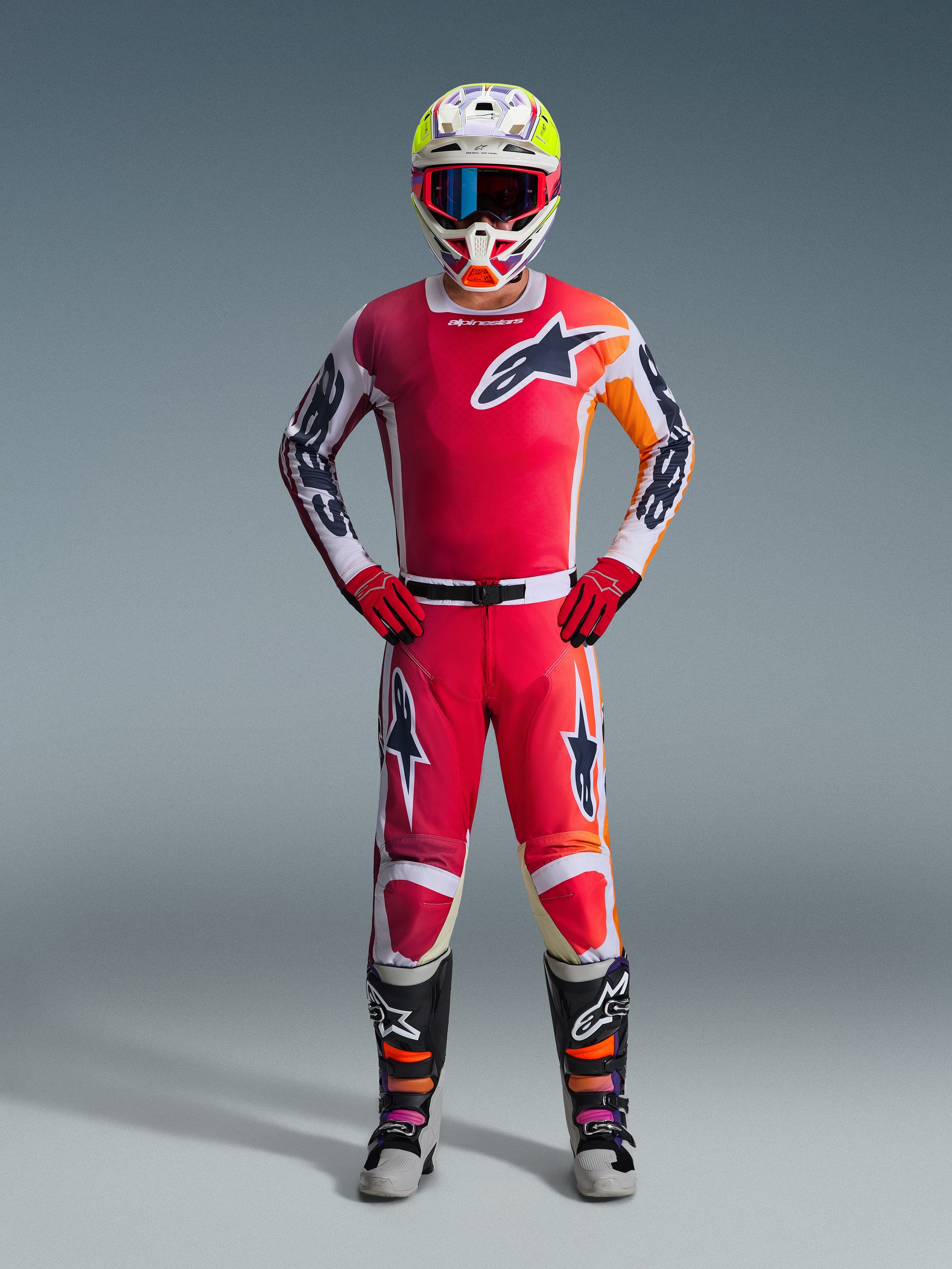 Alpinestars 2026 Racer Portl Gear Set, Motocross-Outfit, Rot und Weiß mit orangefarbenen und schwarzen Akzenten, Stern-Logo auf Brust und Beinen, weißer Helm mit gelben und lila Details, rote Handschuhe, schwarze Stiefel mit orangefarbenen und lila Highlights, komplettes MX-Ausrüstungs-Ensemble