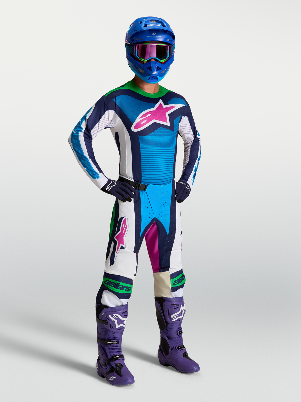 Alpinestars Techstar Maven broek AND Techstar Maven Gear Set, heren motorcrossoutfit in blauw en wit met fluogroene accenten, roze logo en paarse laarzen, professionele off-road race-uitrusting.