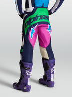 Alpinestars Techstar Maven broek, motorcrossbroek in blauw en groen, achteraanzicht op model met Tech 10 laarzen.
