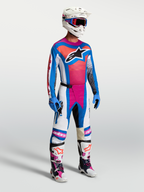 Alpinestars Techstar Maven broek, motorcrossbroek in wit, koraalroze en blauw, getoond op model in complete raceuitrusting.