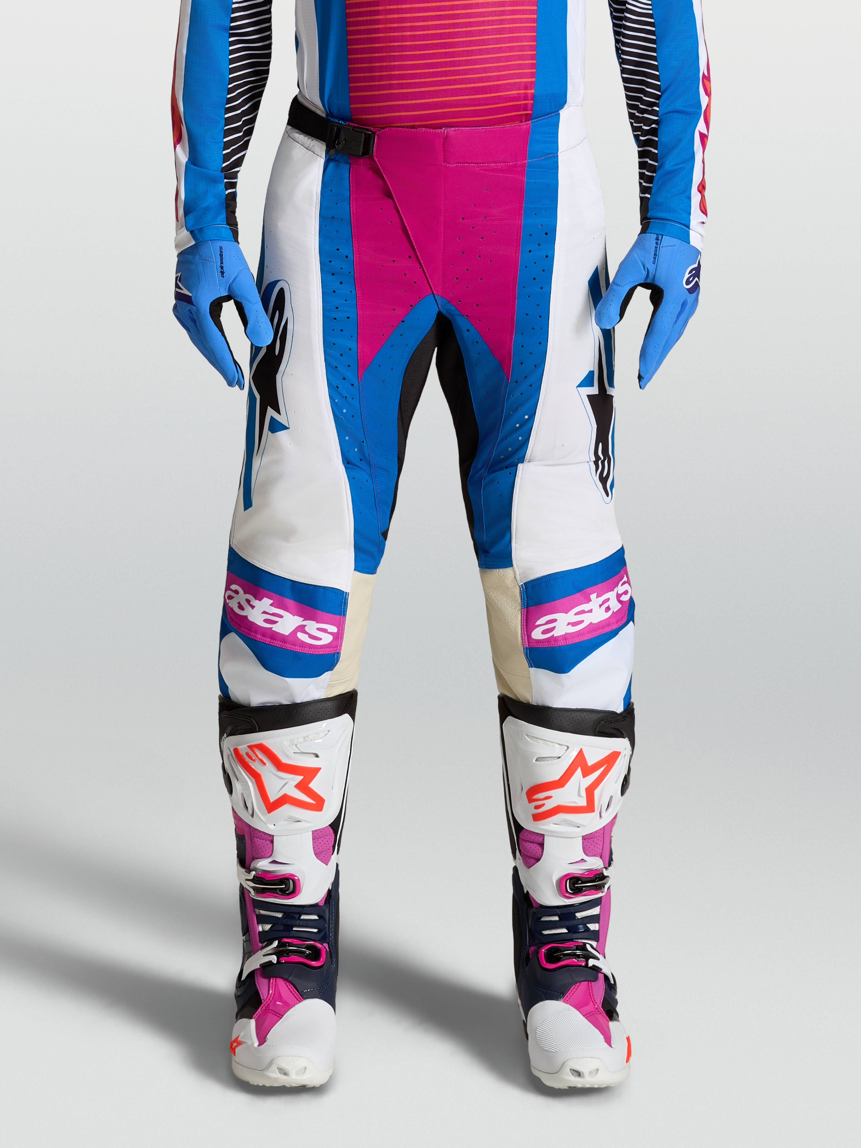 Alpinestars Techstar Maven, pantalon de motocross blanc et bleu avec accents corail, panneaux de genoux en cuir et zones ventilées, idéal pour le pilotage tout-terrain