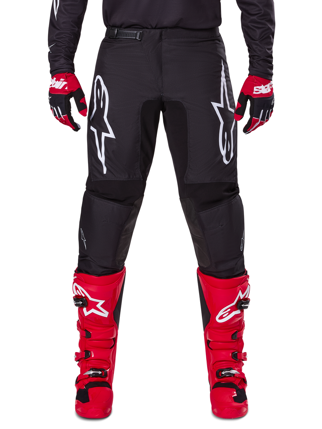 Alpinestars 2025 Fluid Haul Gear Set, schwarze Motocross-Hose mit weißen Astars-Logos auf den Oberschenkeln, kombiniert mit leuchtend roten Stiefeln und rot-schwarzen Handschuhen, abgestimmtes Motocross-Outfit für Offroad-Rennsport