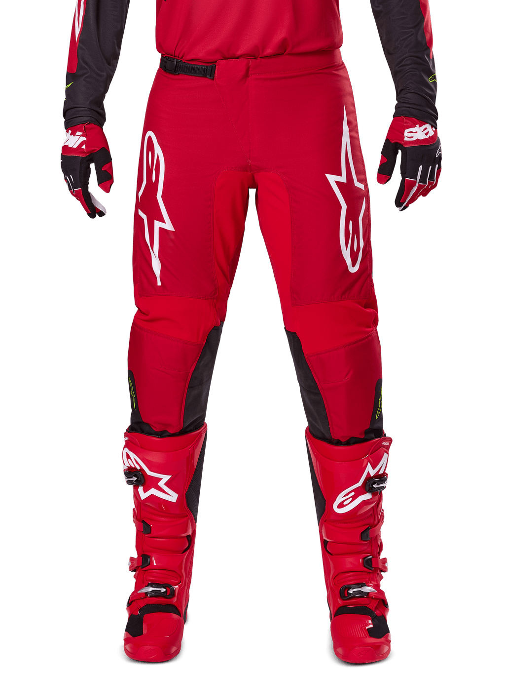 Alpinestars 2025 Fluid Haul Pants, pantalon de motocross, rouge vif et noir, doté de grands logos blancs sur les cuisses et d'empiècements noirs à l'intérieur des jambes, porté avec des bottes et des gants rouges assortis, coupe athlétique pour la performance en motocross