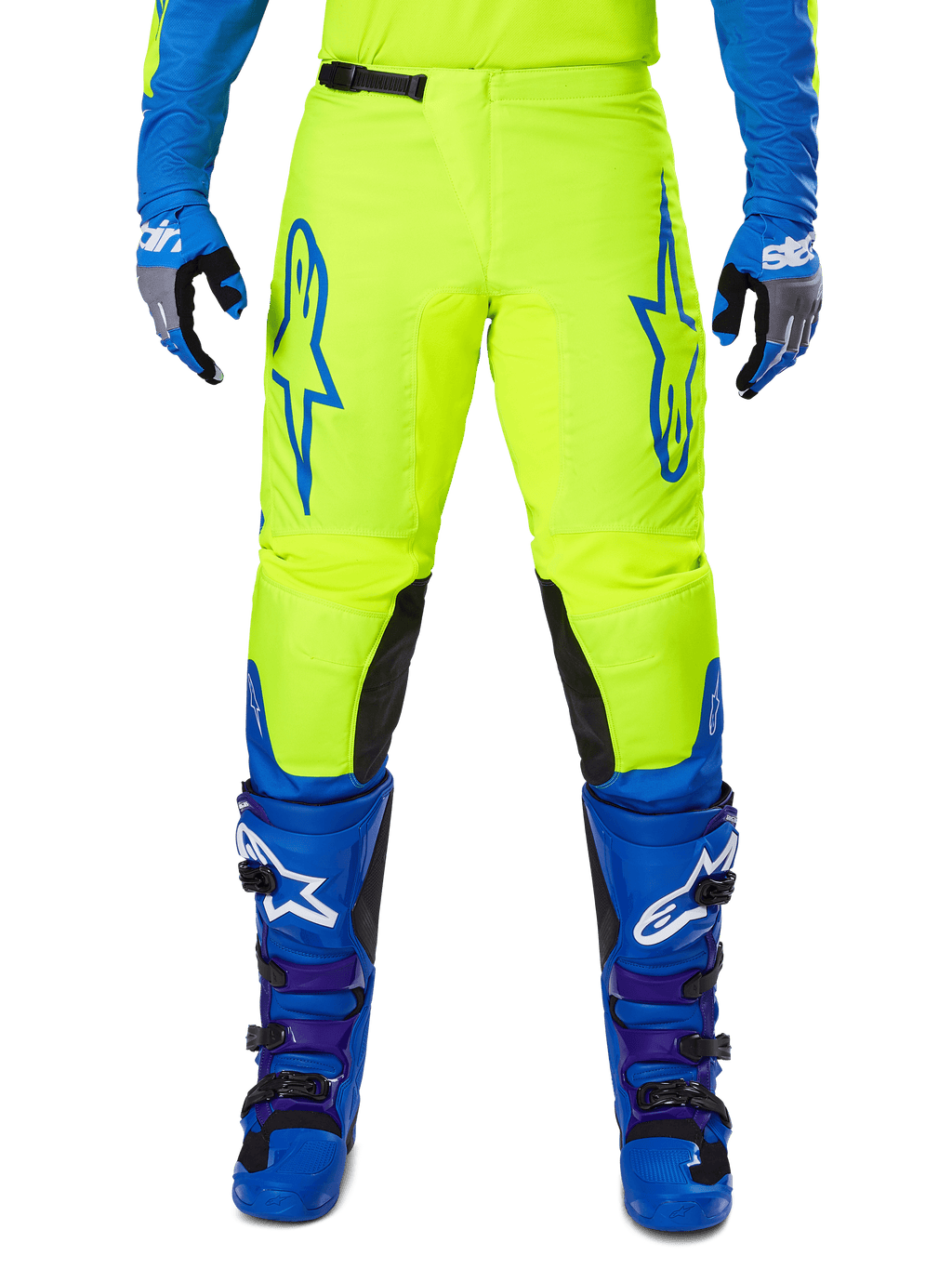 Alpinestars 2025 Fluid Haul motorcrossbroek, felgeel en blauw, gedragen met bijpassende handschoenen en laarzen, zwarte panelen aan de binnenkant van de knieën, opvallende blauwe logo's op de dijen, sportief ergonomisch ontwerp