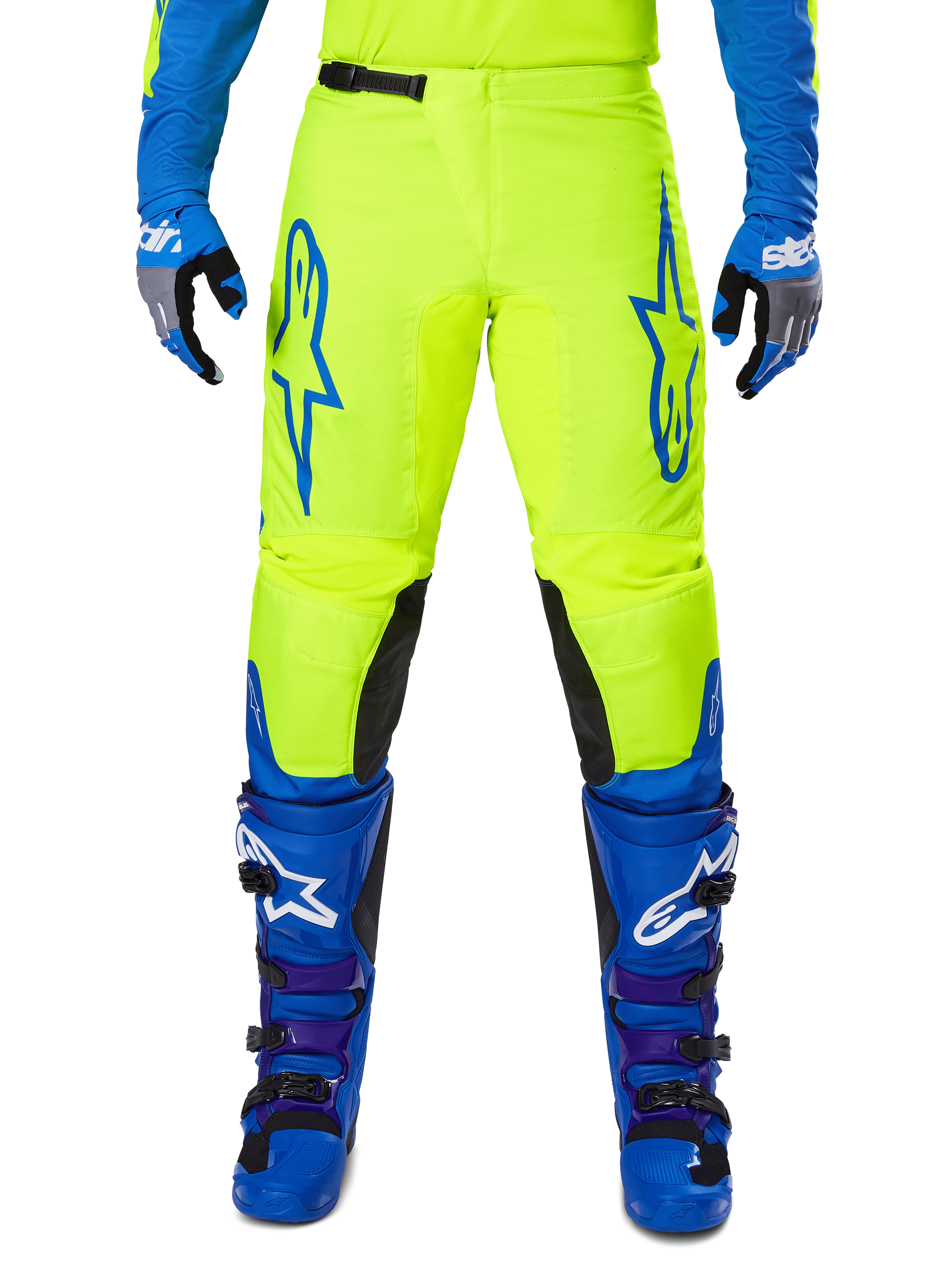 Alpinestars 2025 Fluid Haul Pants, pantalon de motocross, jaune vif et bleu, porté avec gants et bottes assortis, avec des panneaux noirs à l'intérieur des genoux, des logos bleus sur les cuisses et un design ergonomique sportif.