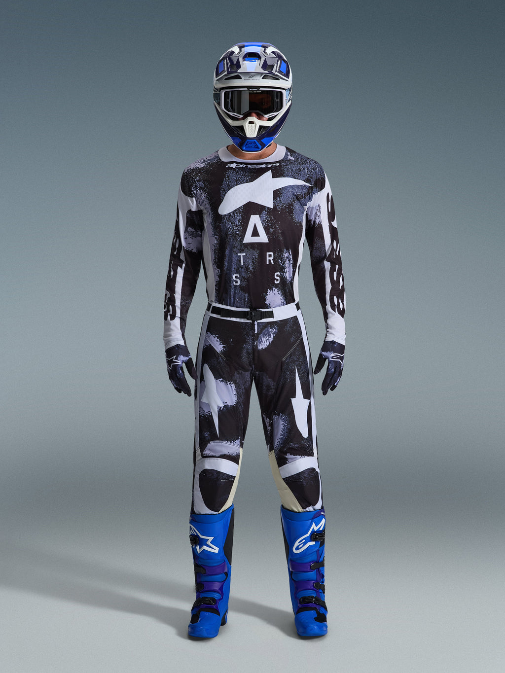 Alpinestars 2026 Racer Lahnd Gear Set, Motocross Outfit, Black and White with Iron Camo abstract pattern, paired with blue and white helmet and bright blue boots, complete racing kit for off-road performance