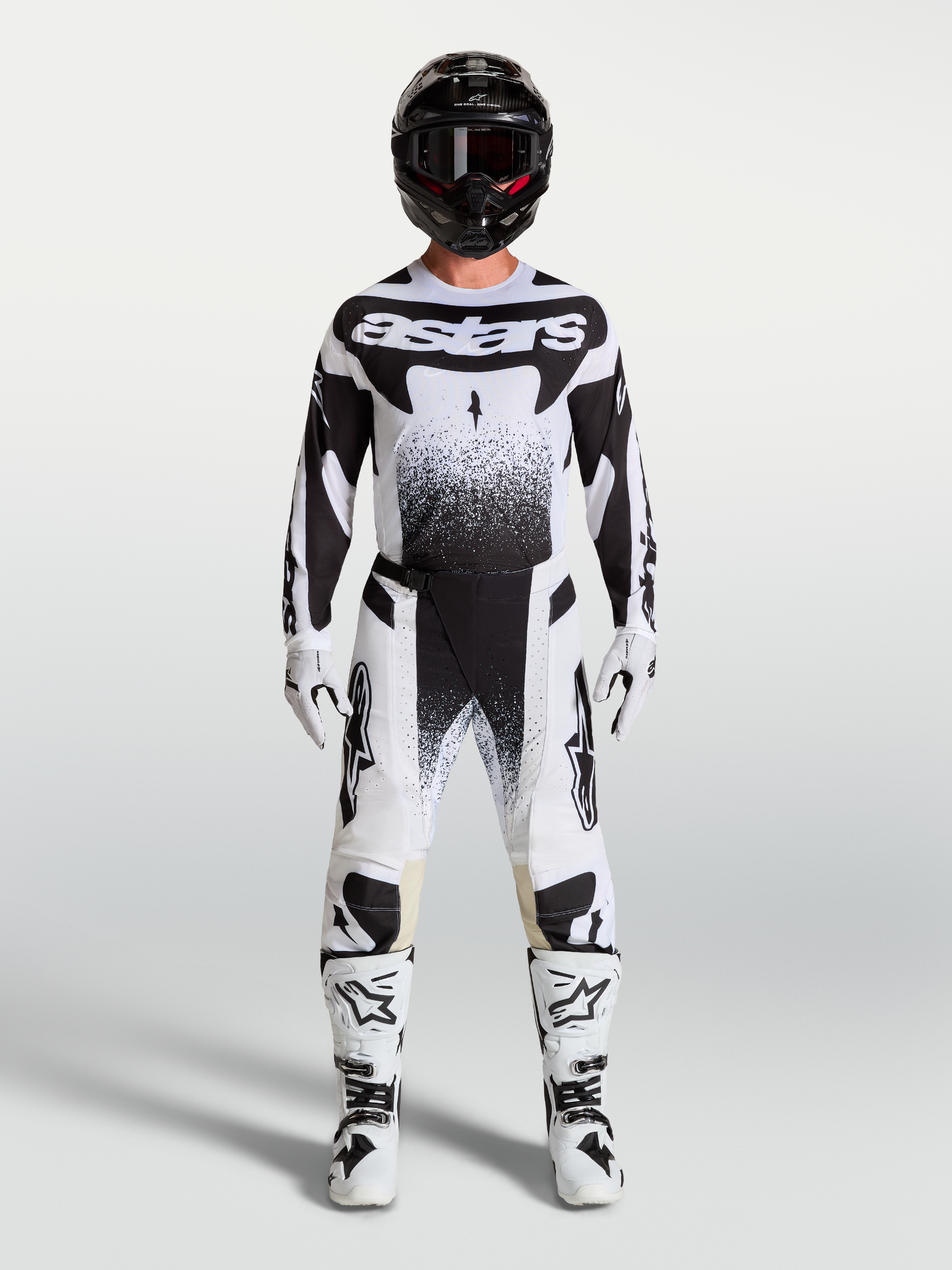 Alpinestars Techstar Swan broek en jersey, wit en zwarte motocross-set gedragen door een model.