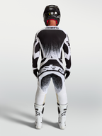 Alpinestars Techstar Swan broek en jersey, heren motorcrossuitrusting, zwart en wit, atletische racepasvorm met rugbranding.