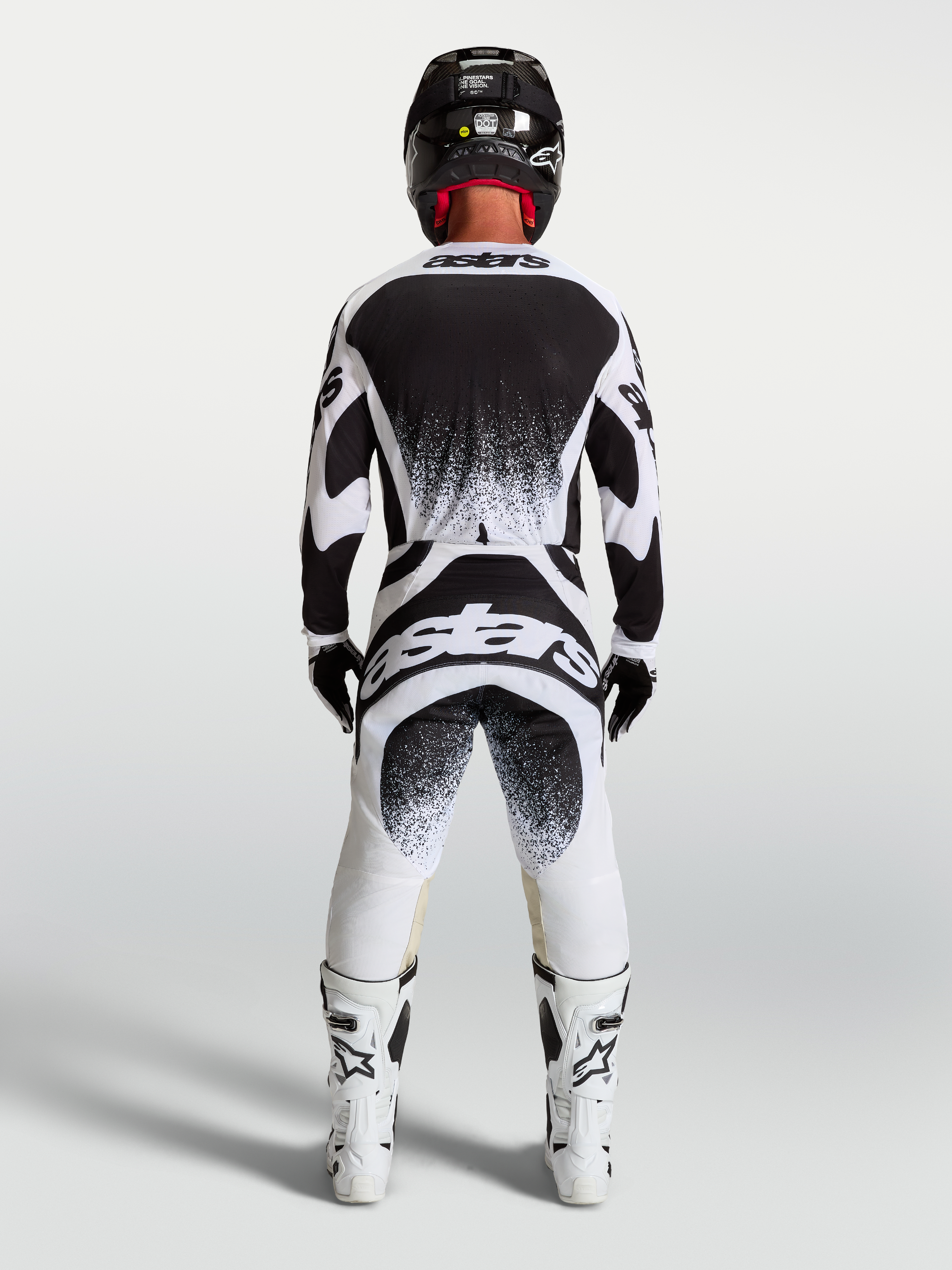 Alpinestars Techstar Swan broek en jersey, heren motorcrossuitrusting, zwart en wit, atletische racepasvorm met rugbranding.