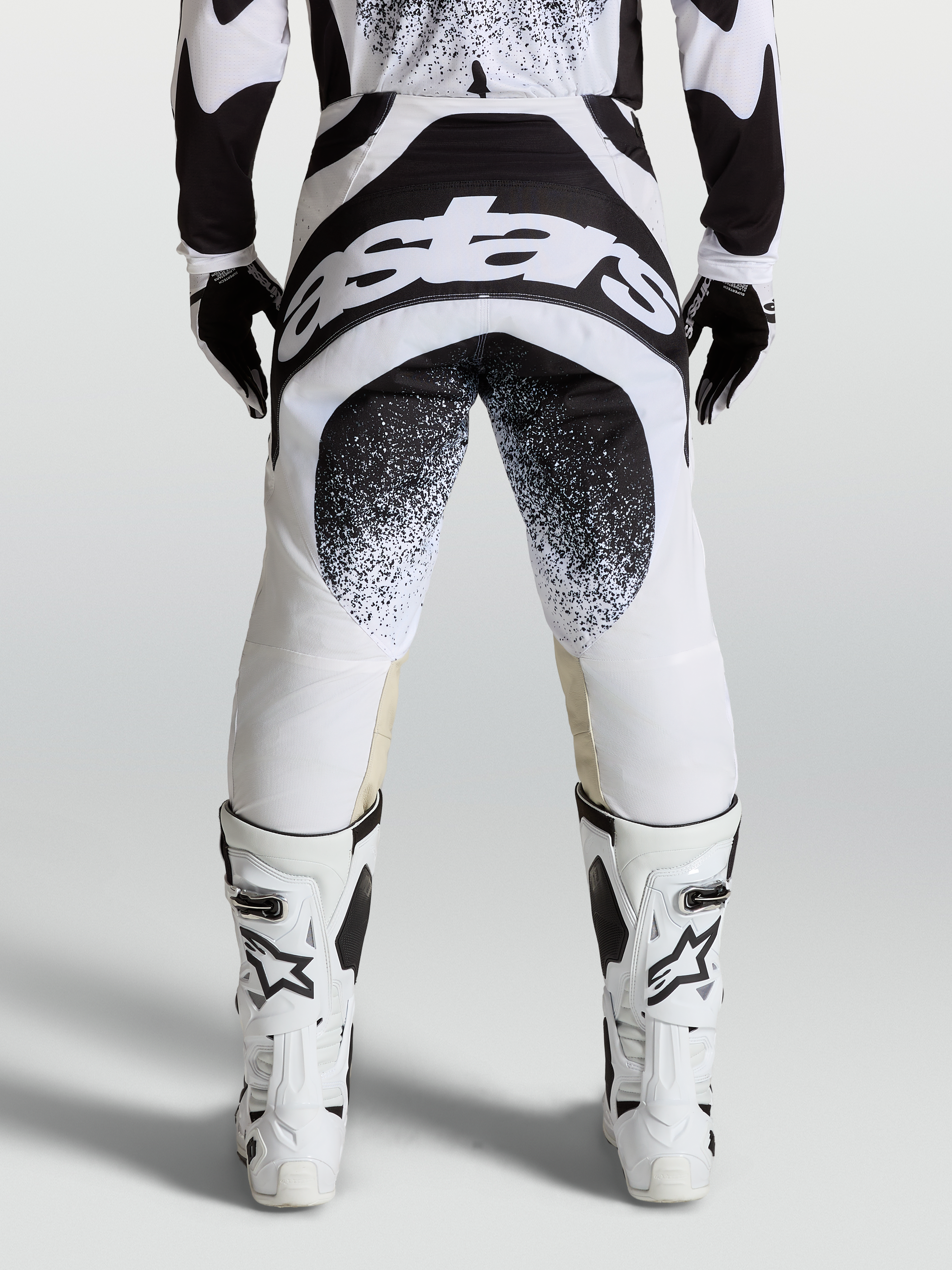 Alpinestars Techstar Swan broek, professionele motorcrossbroek in zwart en wit, achterkant met logo en Babel knieconstructie.