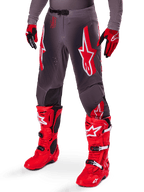 Ensemble d'équipement Alpinestars Supertech Lipan 2025, pantalon de motocross gris avec logos étoiles rouges et blancs, associé à des bottes de performance rouge vif et des gants rouges et noirs, conçu pour la course de niveau professionnel