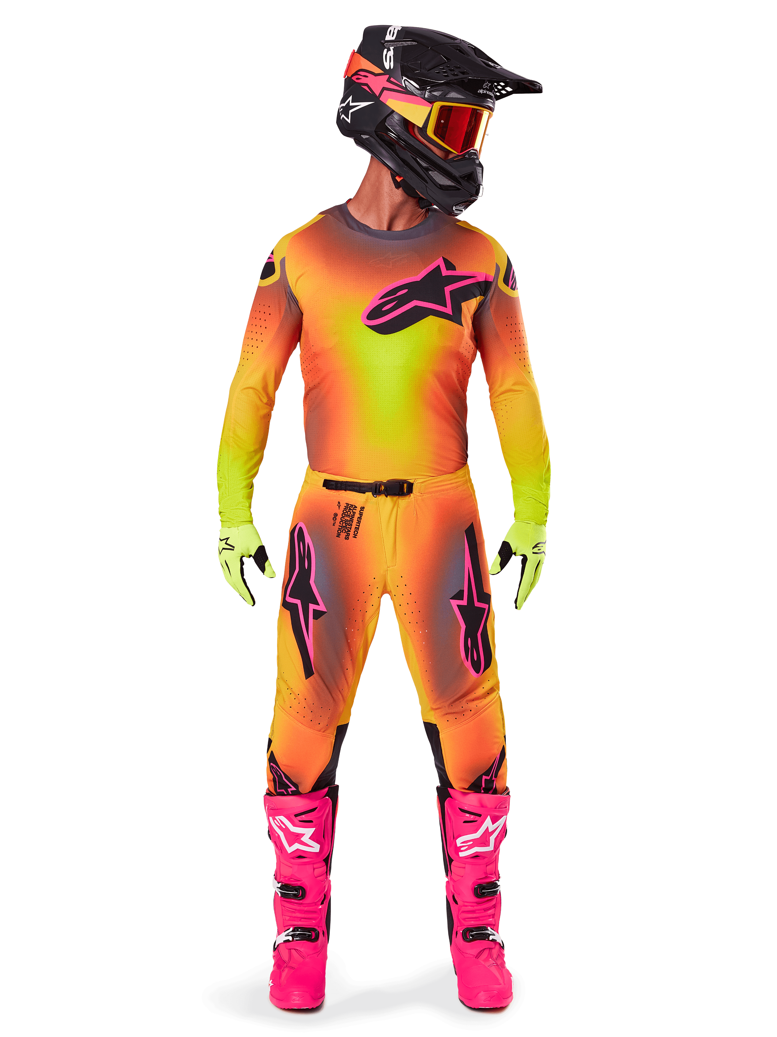 Motocross-Fahrer in der Alpinestars 2025 Supertech Lipan Ausrüstung mit lebhaftem Gelb-Pink-Farbverlauf, passendem langärmeligem Trikot, leuchtend pinken Stiefeln, lindgrünen Handschuhen und schwarzem Helm mit orangefarbener Brille.