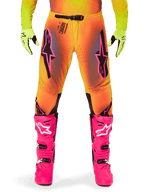 Alpinestars 2025 Supertech Lipan Hose, Motocross-Hose, orange-gelber Farbverlauf mit rosa und schwarzen Akzenten, getragen mit leuchtend rosa Stiefeln und neongelben Handschuhen, mit lasergeschnittener Belüftung und sicherem Taillenverschluss, Profi-Rennausrüstungs-Ensemble