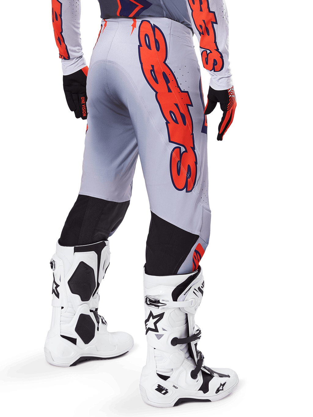 Pantalon Alpinestars Supertech Lipan 2025, pantalon de motocross, gris et orange fluo, porté avec le maillot assorti et des bottes blanches, vue arrière avec grand graphisme Alpinestars orange, empiècements extensibles noirs, équipement de course professionnel