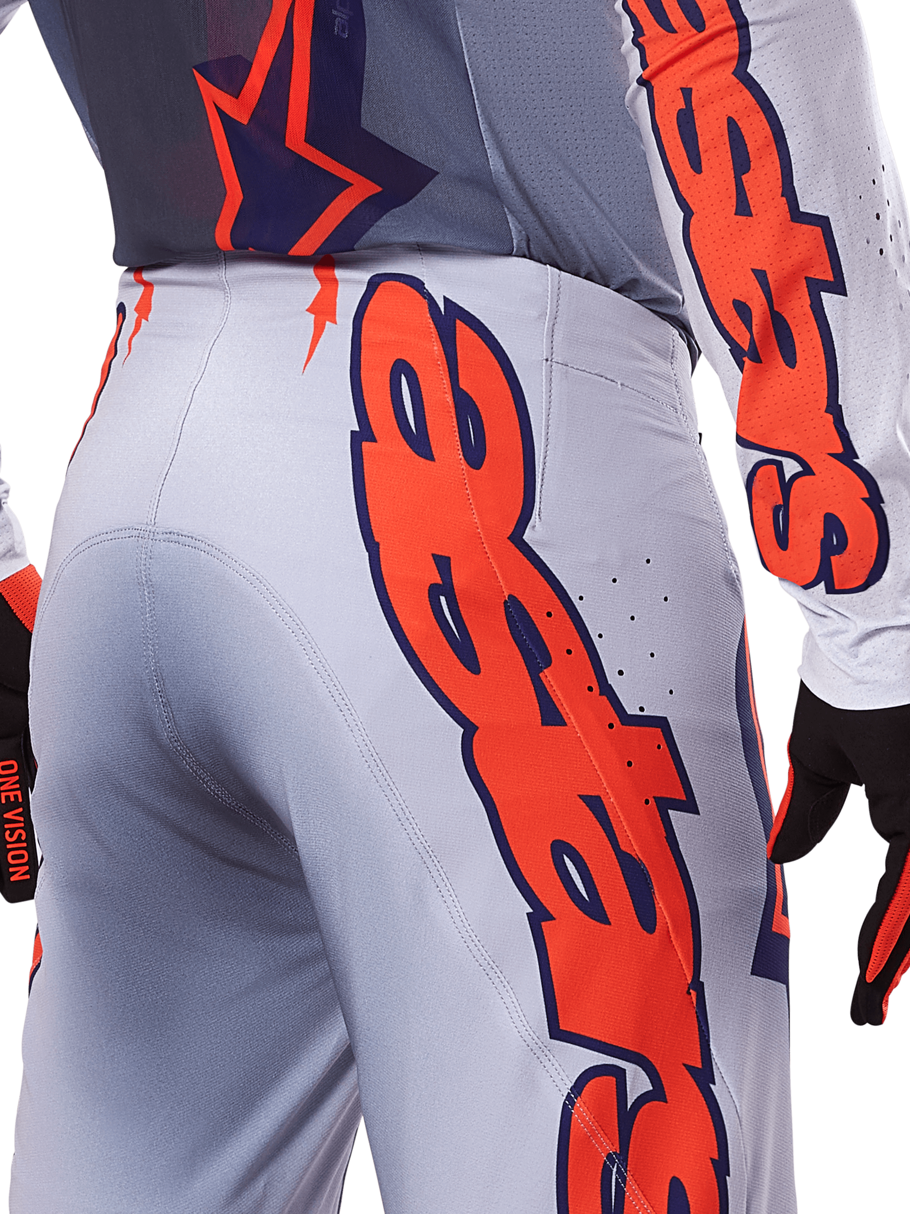 Ensemble maillot et pantalon Alpinestars Supertech Lipan 2025, tenue de motocross, gris et orange fluo, gros plan sur le côté et l'arrière montrant le grand logo Alpinestars orange, tissu ripstop haute performance avec ventilations perforées