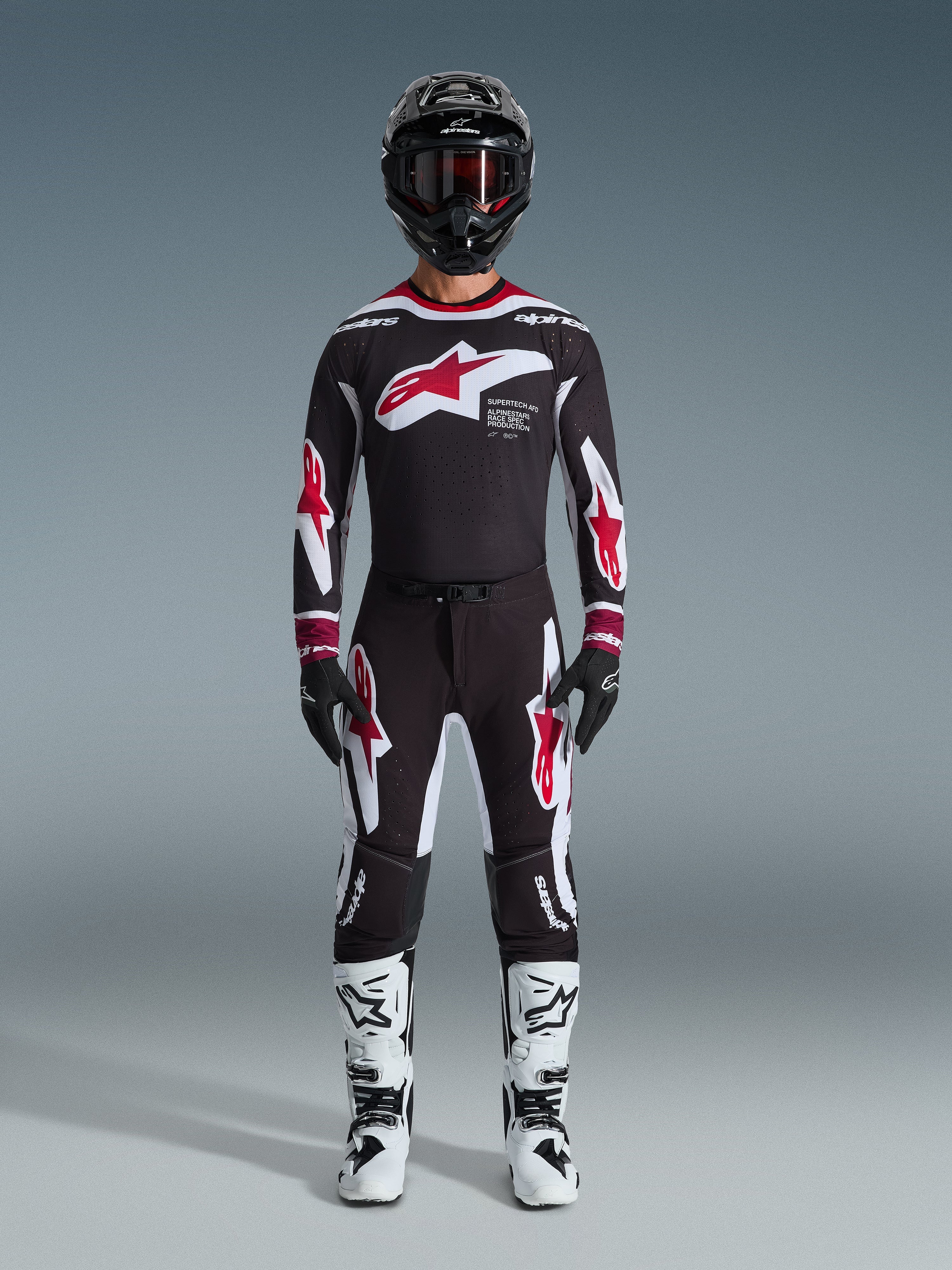 Alpinestars 2026 Supertech AFD Vista Gear Set, Motocross Racing Gear, Black with Red and White accents, full racing outfit including jersey and pants with star logo design, black helmet and white boots, professional MX apparel for off-road performance