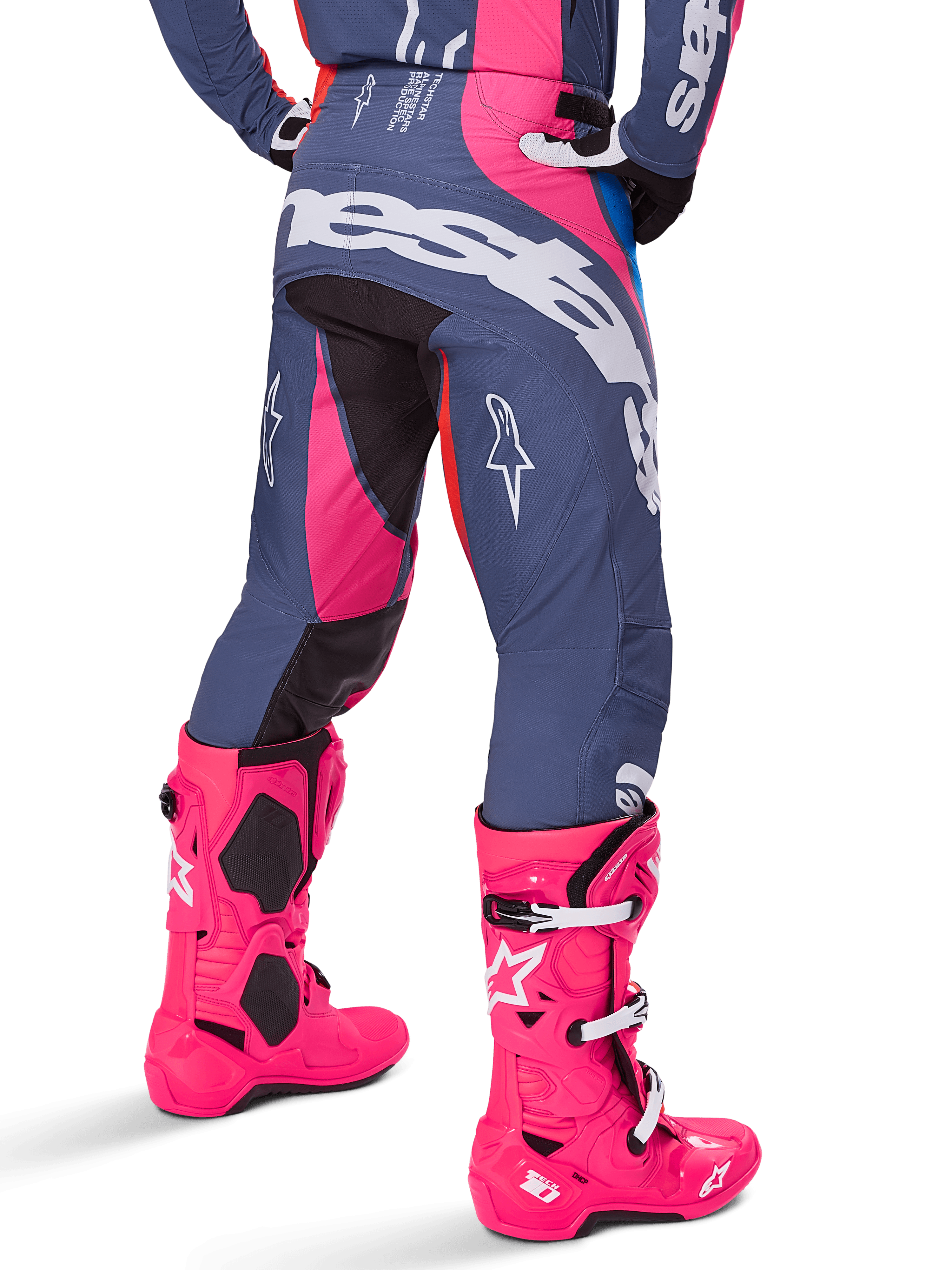Alpinestars 2025 Techstar Dreem Hose, Motocross-Hose, Grau und Pink mehrfarbig, Rückansicht mit großem weißem Alpinestars-Branding auf dem Gesäß, getragen mit passenden leuchtend pinken Tech 10 Stiefeln, strapazierfähige Offroad-Rennausrüstung mit verstärkten Einsätzen.