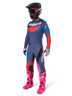 Alpinestars 2025 Techstar Dreem Hose, Motocross-Hose, Grau Multicolor mit blauen, roten und pinkfarbenen Akzenten, getragen mit passendem Trikot und leuchtend pinkfarbenen Stiefeln, mit schwarzem Helm und weißen Handschuhen, komplette Ausrüstung für Offroad-Rennsport