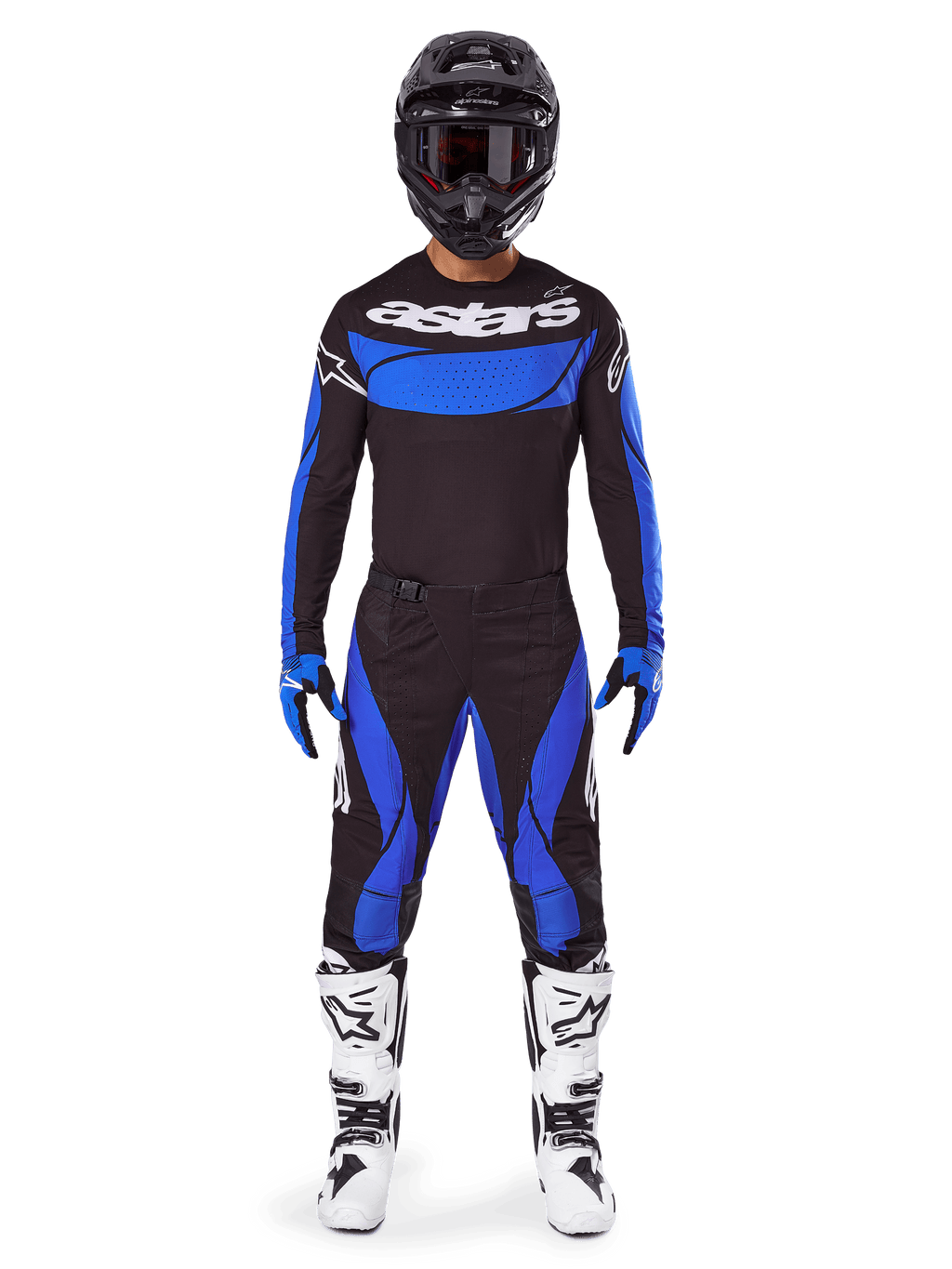 Pilote de motocross portant l'ensemble Alpinestars 2025 Techstar Dreem, maillot noir avec panneau de poitrine et manches bleus, pantalon noir et bleu assorti, casque noir avec lunettes et bottes blanches, tenue de motocross complète coordonnée pour la course tout-terrain.
