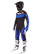 Alpinestars 2025 Techstar Dreem Gear Set, équipement de motocross noir et bleu, incluant un maillot et un pantalon avec logos blancs, porté avec un casque noir, des gants bleus et noirs et des bottes blanches et noires, tenue de course coordonnée pour la performance tout-terrain.